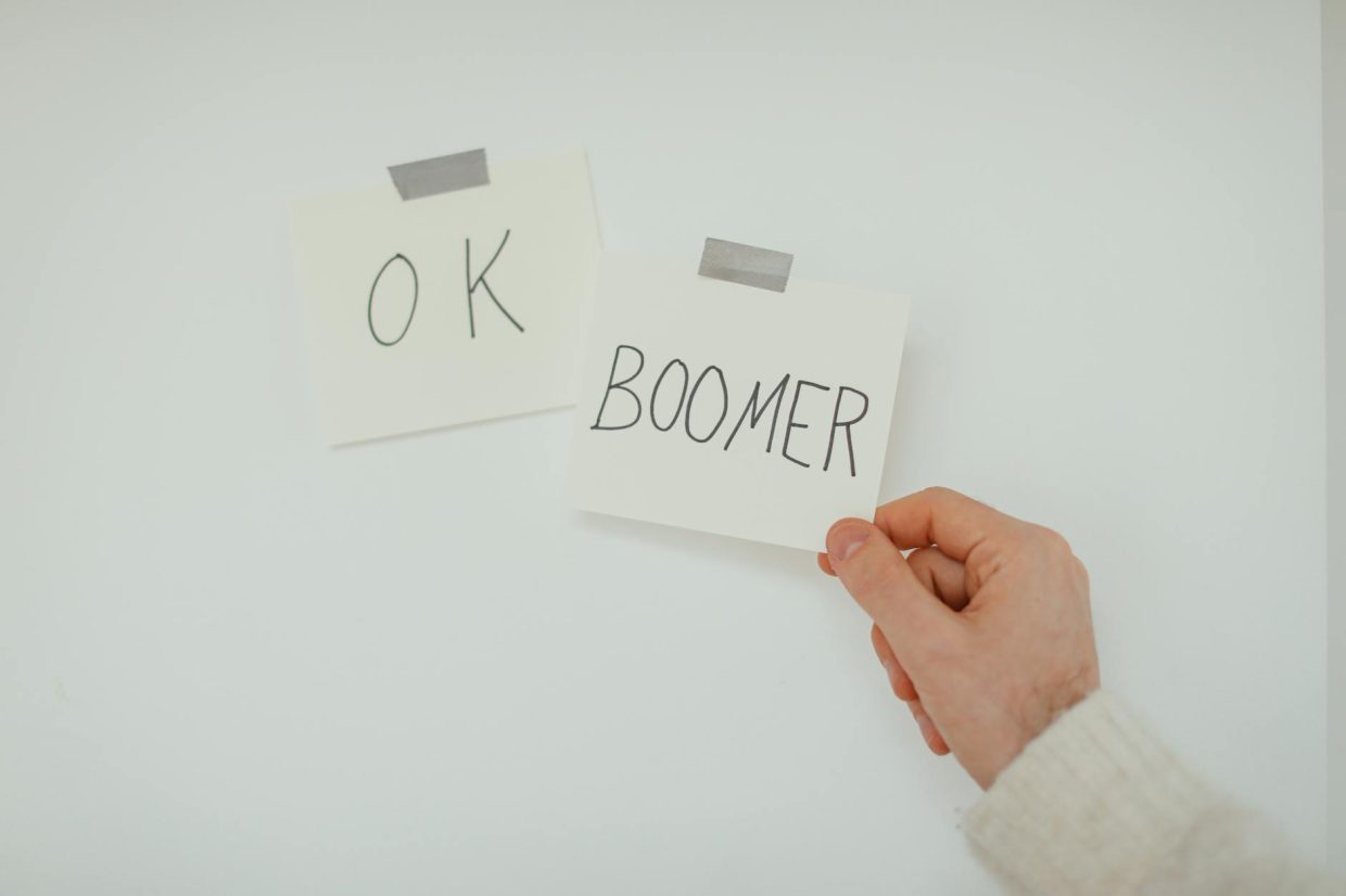 a hand holding the sticky notes posted on a white wall